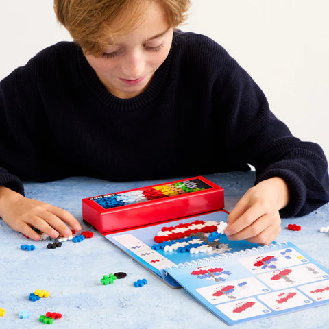 Child playing with colorful interlocking blocks on a table