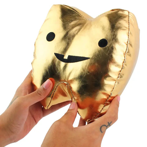 Image shows two hands holding up the stuffed gold tooth