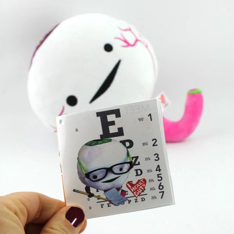 Image shows the eyeball next to a page of the information card it comes with, showing an eye test.