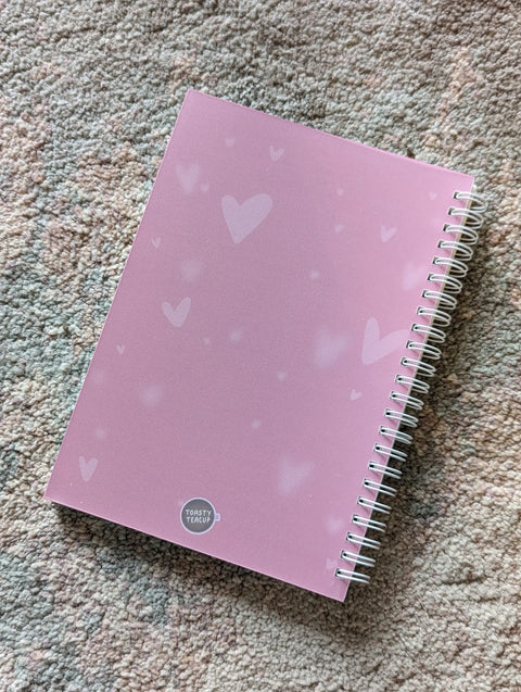 Image shows the back of the sticker book. It is pink with light pink hearts.