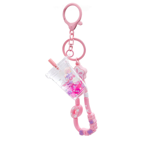 Image shows a pink keychain with a boba charm and a sensory charm with various beads
