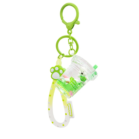 Image shows a green keychain with a puppy in a boba cup. It also has a rubber strap with a puppy paw on top.