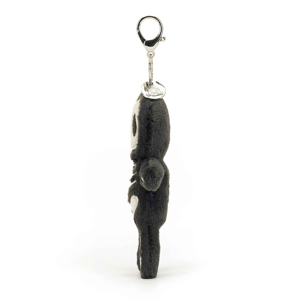 Side view of a stuffed skeleton hanging from a clip keychain