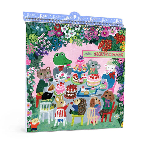 Image shows a kids' sketchbook. It has various animals sitting around a table with a bunch of sweets.
