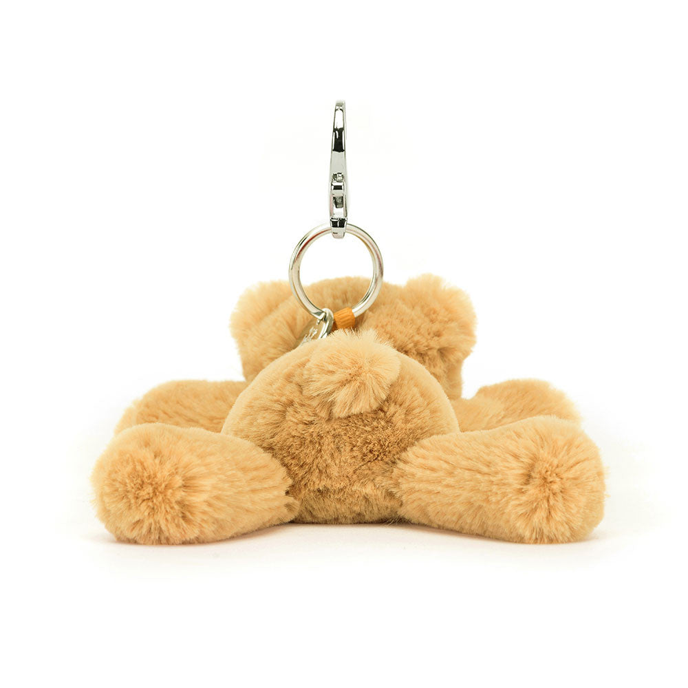 The back view of a floppy tan teddy bear hanging from a clip keychain