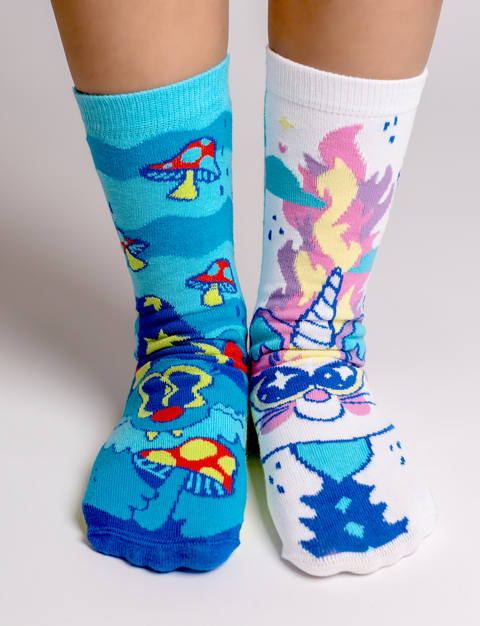 Image shows a woman wearing the socks. The sorcerer cat is blue and the unicorn cat is white.