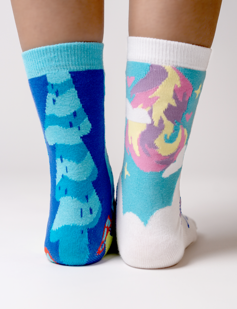 Image shows the back of the socks. The sorcerer cat has a long blue tail and the unicorn cat has a short rainbow tail.