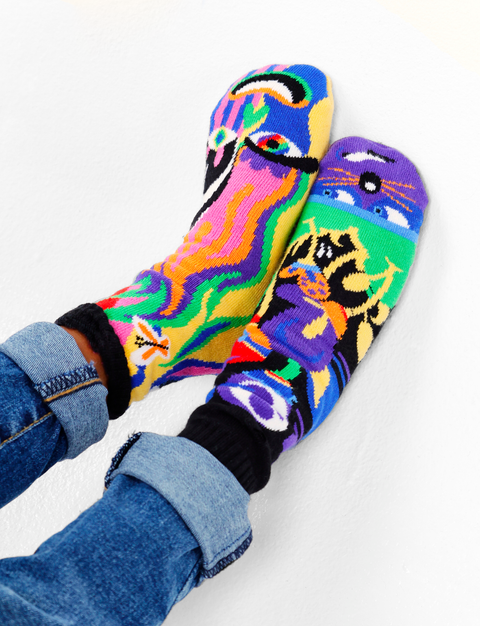 Image shows a pair of abstract art socks. One is a shy person while the other is an outgoing person.