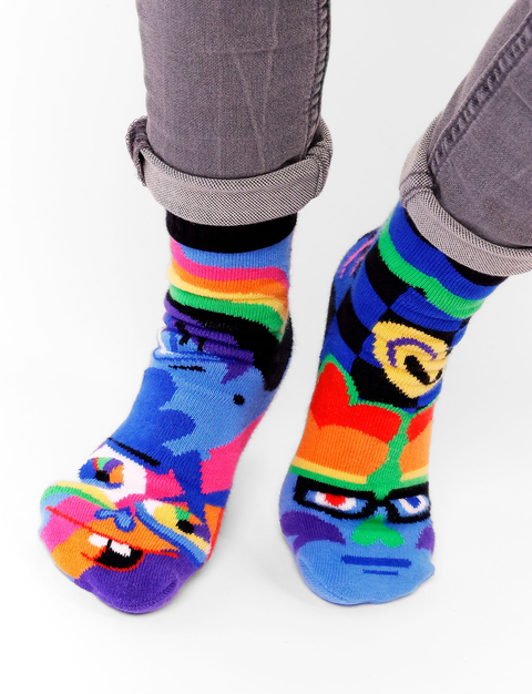 Image shows a pair of abstract art socks. One is a silly face and one is a serious face.