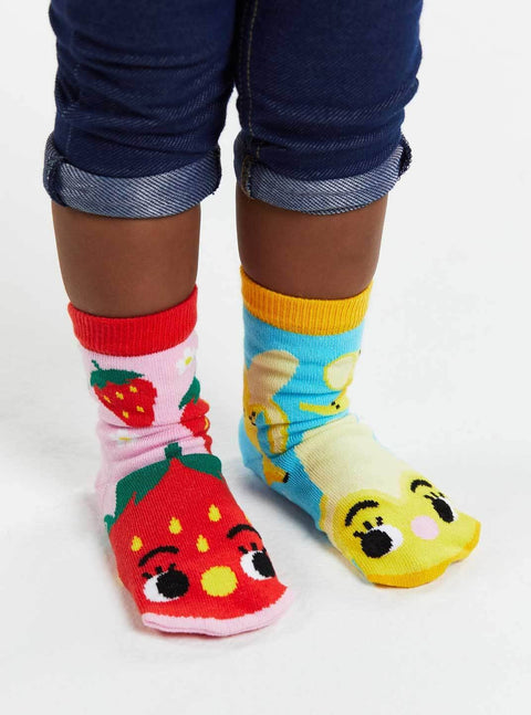 Image shows a pair of mismatched kids socks. One is strawberries with a face, one is bananas with a face.
