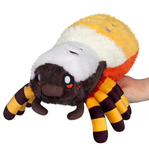 Plush toy resembling a spider with a round body on a white background. It is brown, white, yellow, and orange.