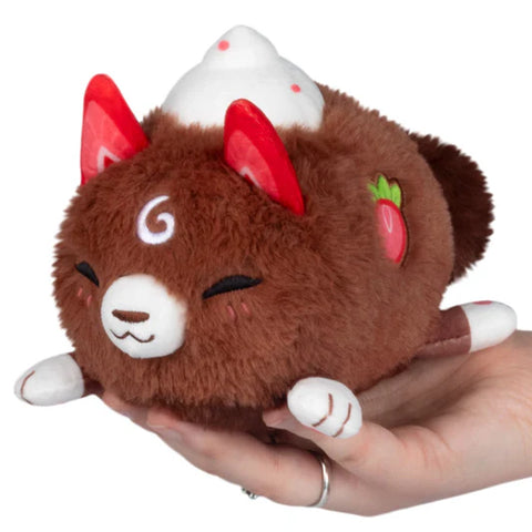 A brown stuffed kitsune with strawberries for ears and whipped cream on its back