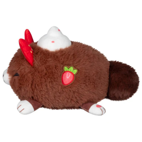 A side view of the cocoa-themed stuffed kitsune. Its body is round, and it has a strawberry on its side.