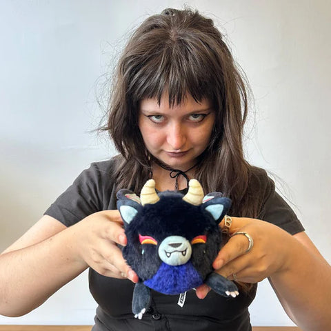 A woman holding the stuffed demon kitsune. It is slightly smaller than her head.