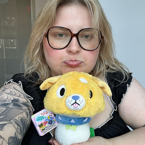 Image shows a woman holding the stuffed dog mushroom. It is approximately the size of her head.