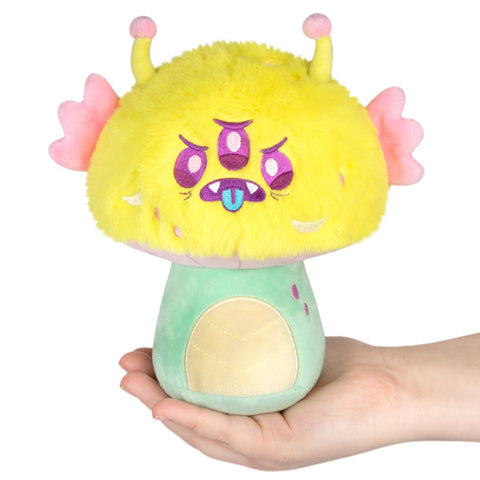 Image shows a yellow mushroom with three eyes, tentacles, and pink ears.