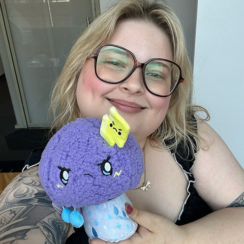 Image shows a woman holding the stuffed stormy mushroom. It is about the size of her head.