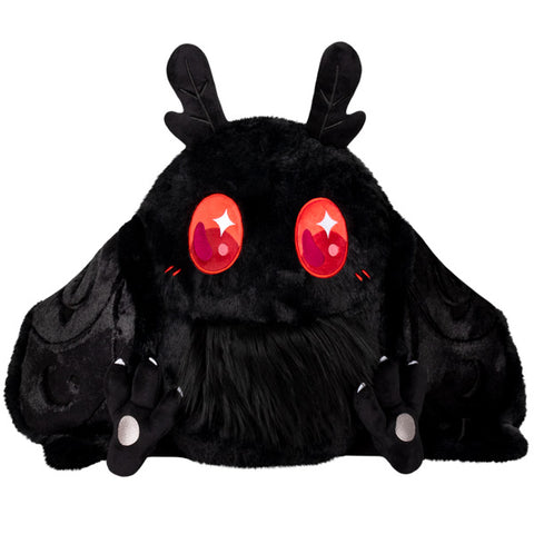 A plush toy resembling a baby Mothman with black fur, red eyes, and wing tips that appear to be magnetic.