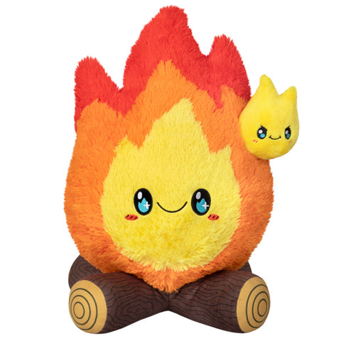 A plush toy resembling a campfire with a friendly face, orange and yellow flames, and a small yellow flame character on top.