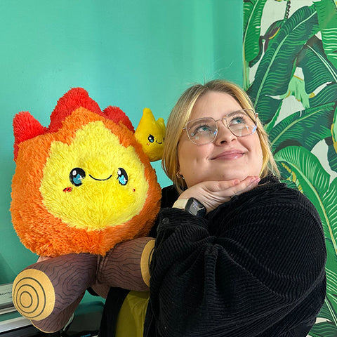 A woman holds the plush campfire. It is about the size of her torso.