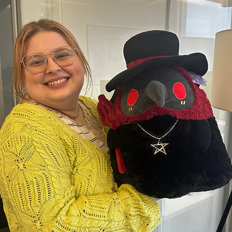 Image shows a woman holding the stuffed demon plague doctor. It is slightly smaller than her torso.