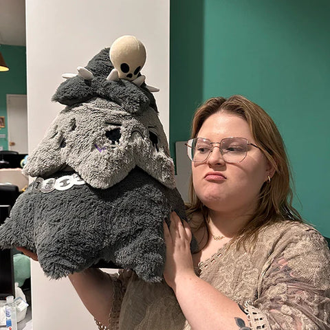 Image shows a woman holding the goth Christmas tree up to her head. It is significantly larger than her head.