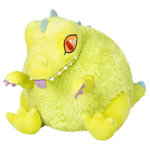 A plush toy resembling the character Reptar from Rugrats, with a bright green body, orange eyes, and a yellow color scheme.
