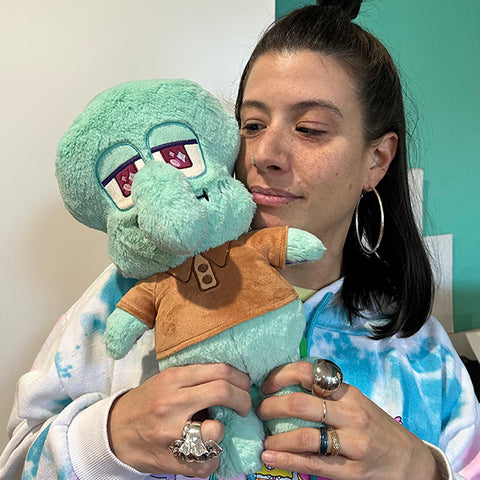 Image shows a woman holding the stuffed Squidward. It is larger than her head.