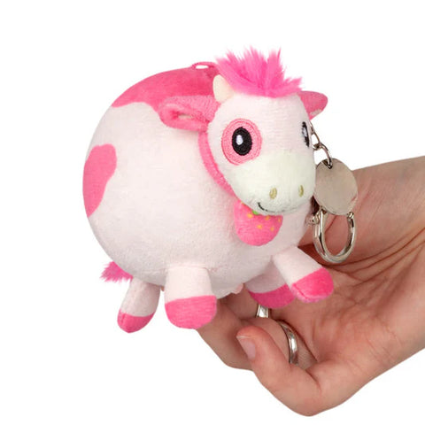 Image shows a stuffed pink cow attached to a silver clip keychain