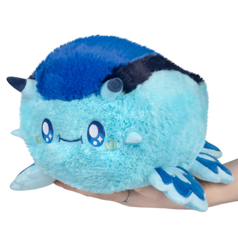 Blue dragon sea slug plush held in someone's hand, on a white background.