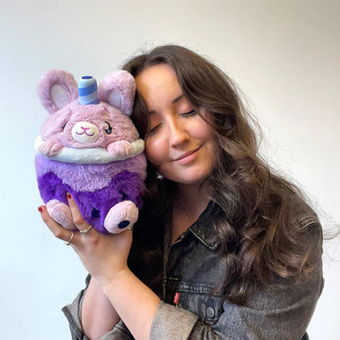 Image shows a woman holding the purple bunny bubble tea up to her face. It is slightly larger than her head.