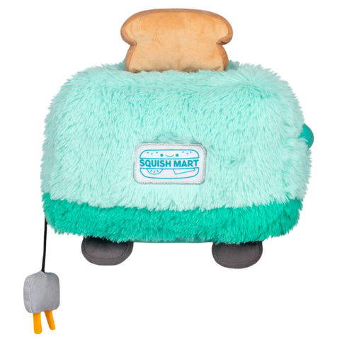 Plush toy resembling a toaster with a piece of bread on top, branded 'Squish Mart', on a white background.