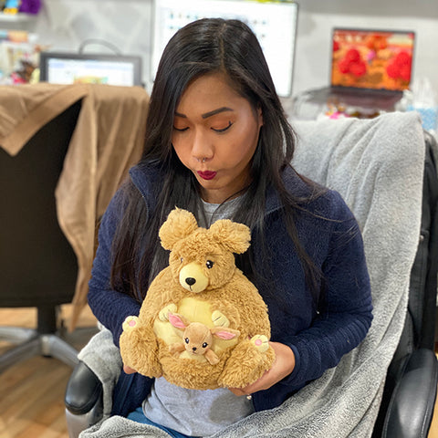 Image shows a woman holding the stuffed kangaroo in her lap. It is slightly larger than her head.