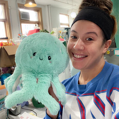 Image shows a woman holding up the mint stuffed octopus. It is approximately the size of her head.