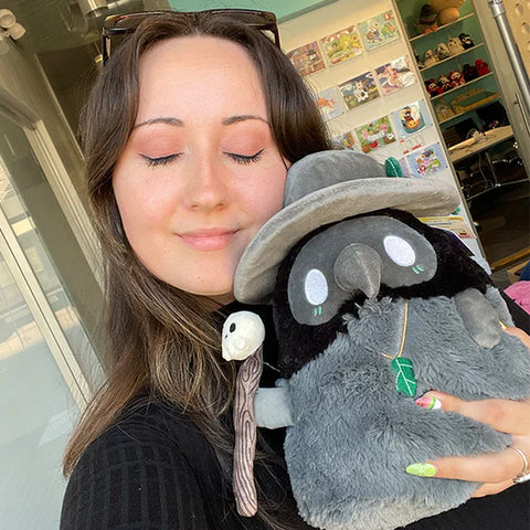 Image shows a woman holding the druid plague doctor. It is slightly larger than her head.