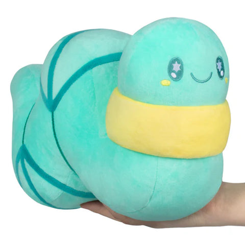 Plush toy in the shape of a teal worm with a smiling face held in a hand against a white background