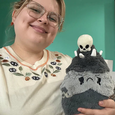 Image shows a woman holding the goth-themed stuffed Christmas tree. It is about the size of her torso.