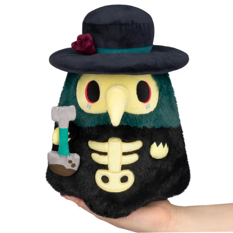 Plush plague doctor with a skeleton chest, dark green hat, and shovel in his hand. It is graveyard-themed.