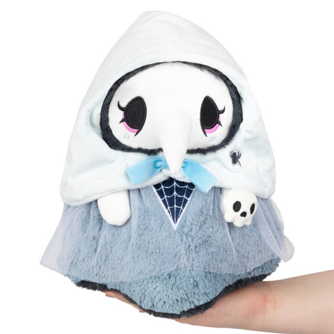 Image shows a stuffed haunted themed plague nurse. She is pale blue with a white bonnet, and is holding a skull.