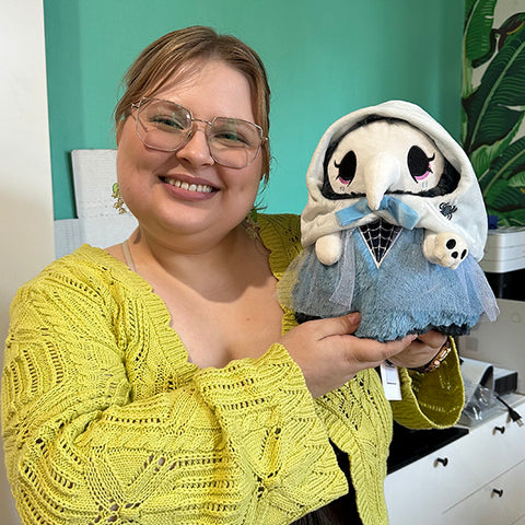 Image shows a woman holding the haunted plague nurse. She is slightly larger than her head.