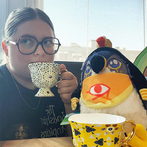 Image shows a woman sitting next to the stuffed Horus. It is slightly larger than her head.