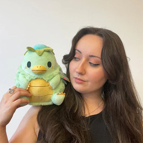 Image shows a woman holding the stuffed kappa. It is about the size of her head.