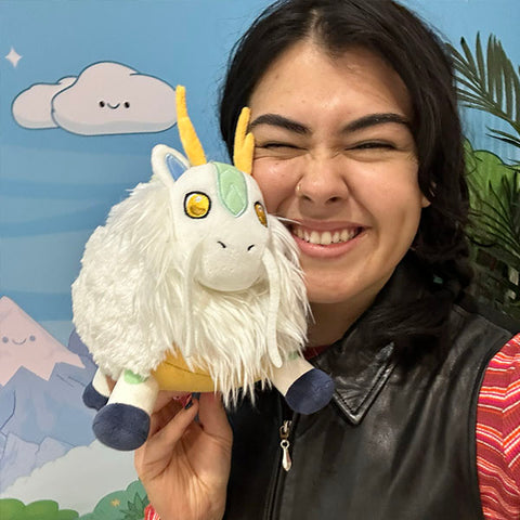 A woman holds the plush Kirin near her face. It is slightly larger than her head.