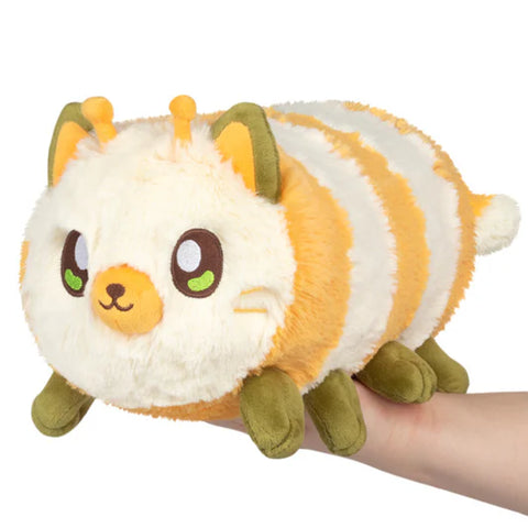 Image shows a stuffed kittypillar - half kitty half caterpillar. It is white and yellow striped with a cat face and eight legs.