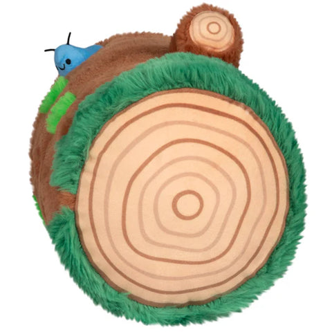 Plush toy resembling a snail on a wooden log with a white background