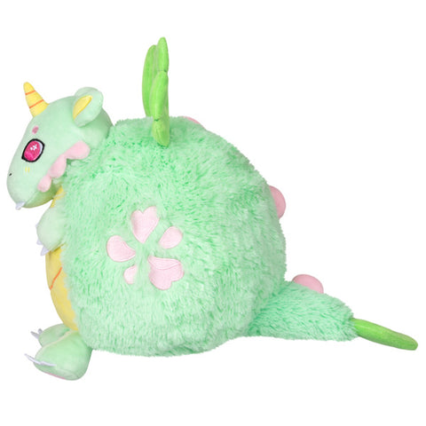 A side view of the plush petal dragon. It has pink spots embroidered into its side.