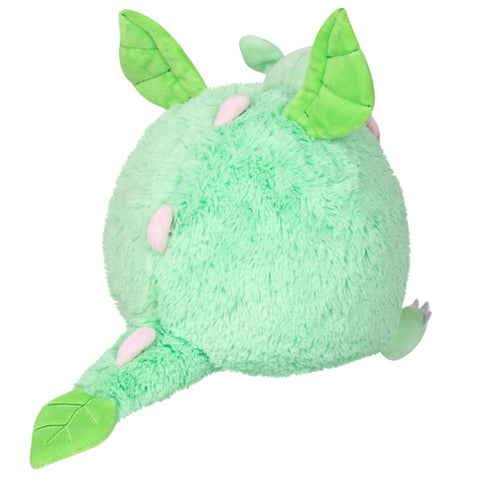 A back view of the plush petal dragon. It has pink spikes down its back and its tail tip resembles a leaf.