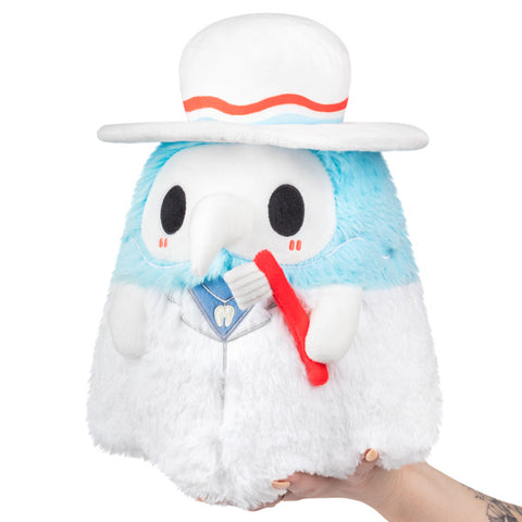 A light blue Plague Doctor wearing a white had, white jacket, and holding a red toothbrush. It is held in someone's hand.
