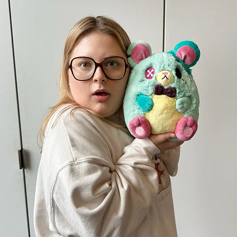 Image shows a woman holding the stuffed rat up to her face. It is slightly larger than her head.