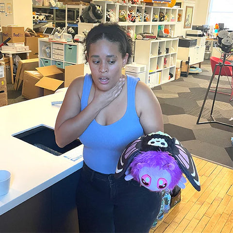 Image shows a woman holding the posion hawkmoth in her hand